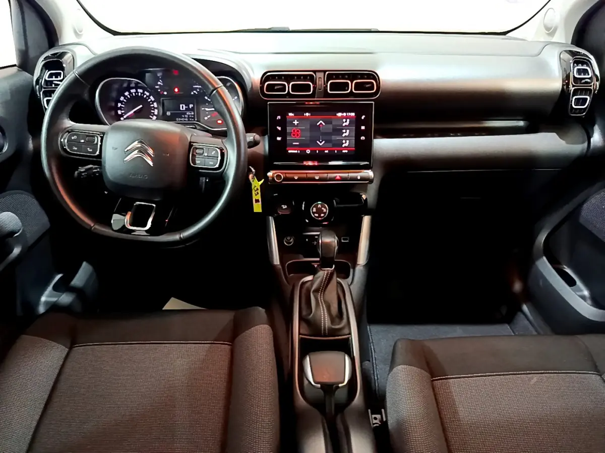 Intérieur du Citroën C3 Aircross 2019 en vue frontale, tableau de bord noir avec écran tactile central et volant multifonctions.