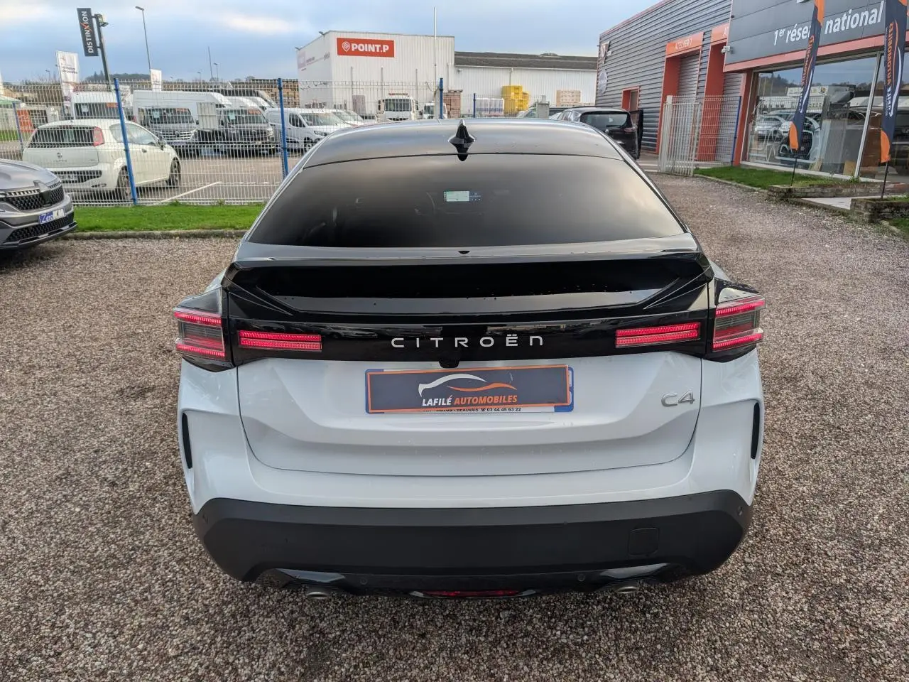 Vue arrière d'une Citroën C4 blanche avec toit noir Perla Nera et feux arrière LED distinctifs.