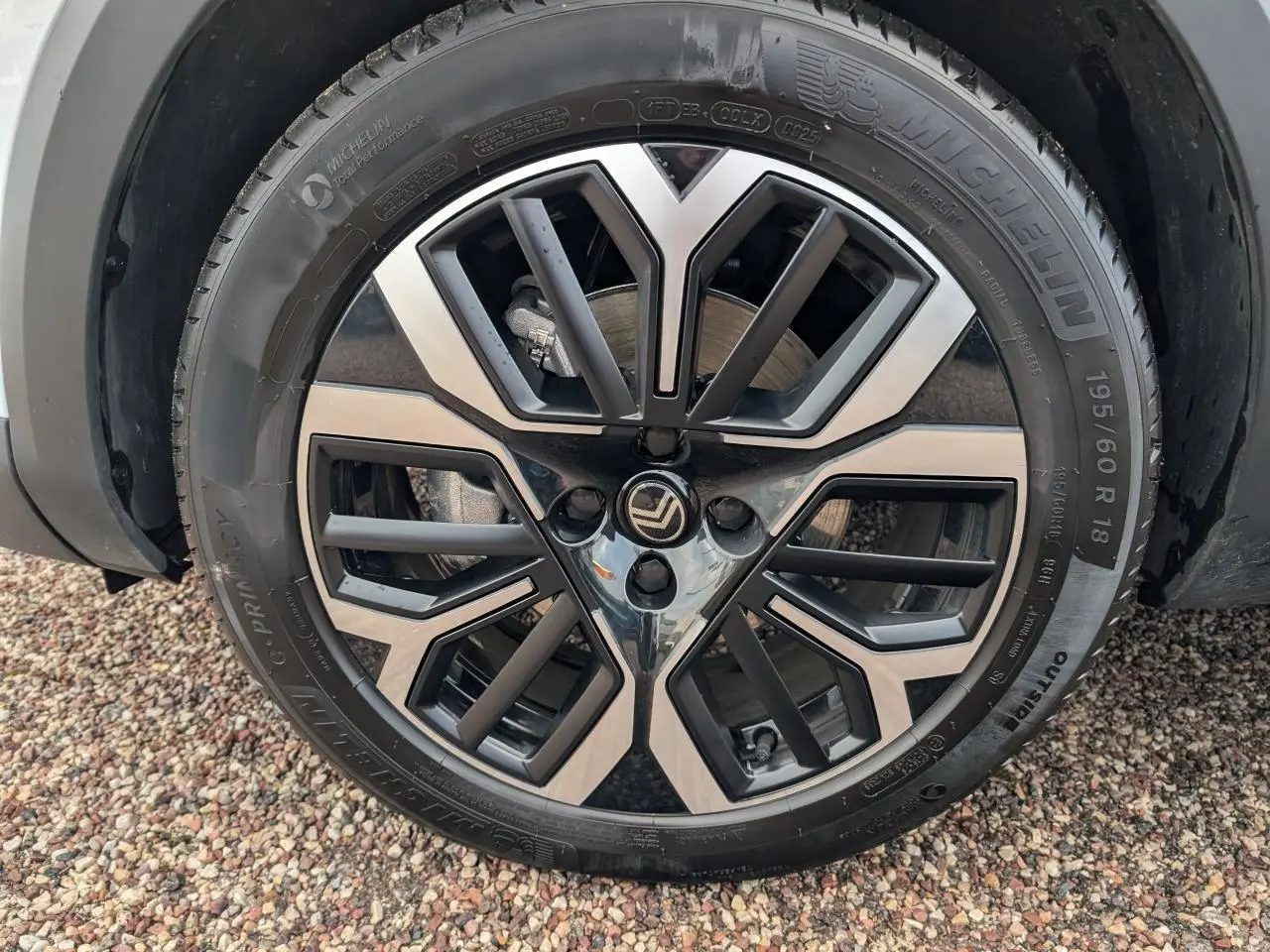 Gros plan sur la jante alliage 18 pouces diamantée noire et argent d'une Citroën C4 blanche, roue avant gauche.