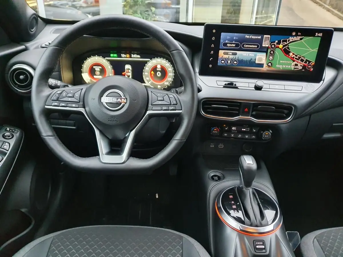 Vue intérieure frontale du tableau de bord du Nissan Juke 2025 avec volant multifonction et écran tactile 12,3 pouces.