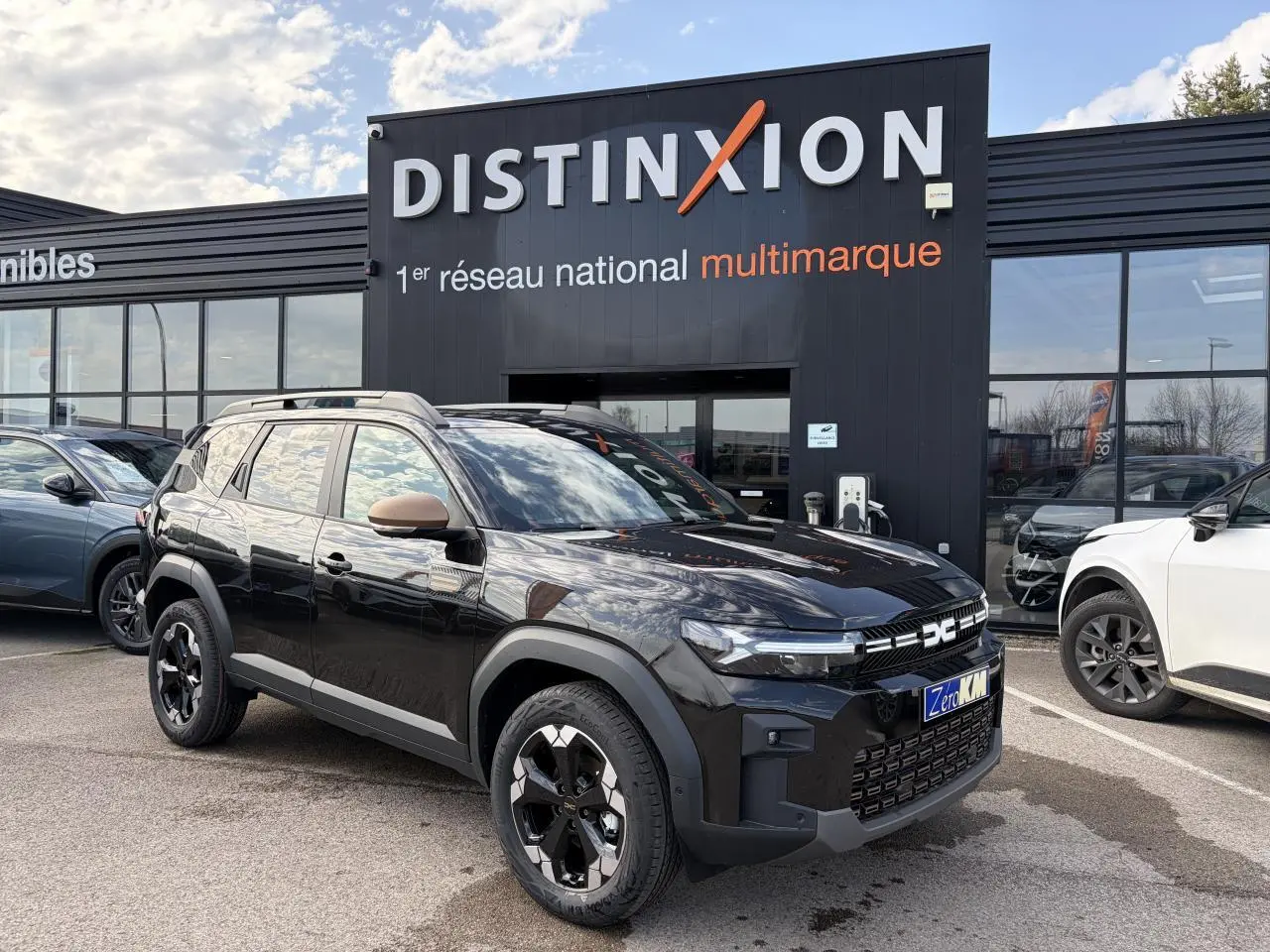 Vue 3/4 avant d'un Dacia Bigster noir nacré avec détails brun cuivré sur les rétroviseurs et la calandre, roues alliage 18 pouces.