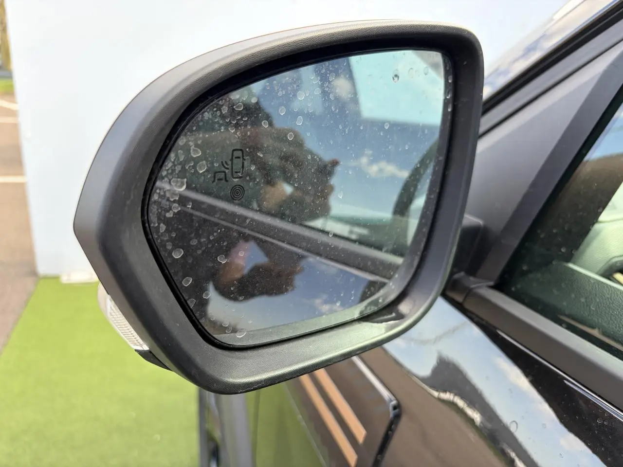 Rétroviseur extérieur côté gauche du Dacia Bigster noir nacré avec détection des angles morts visible.