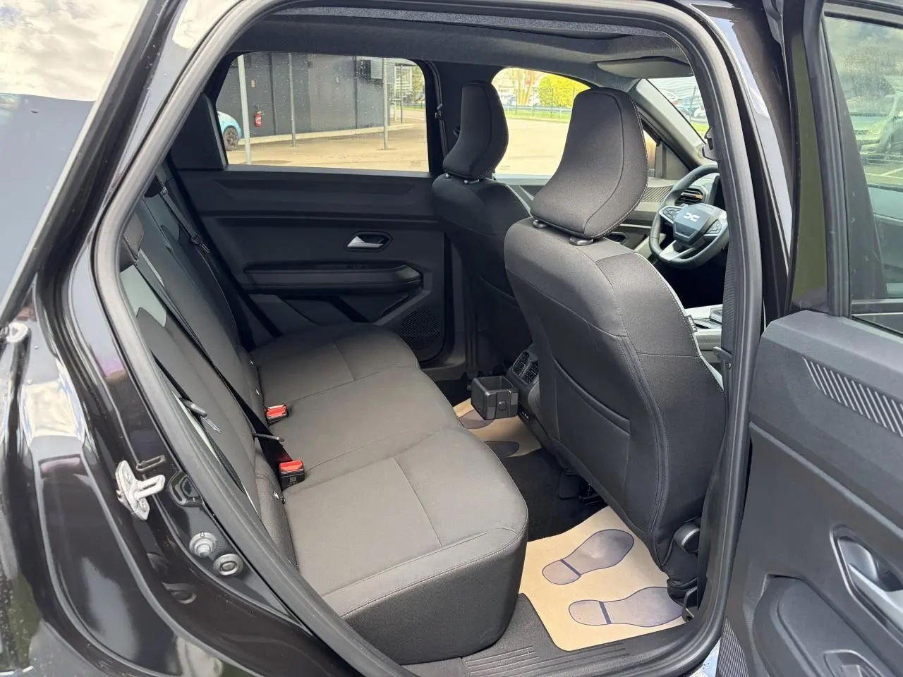 Vue intérieure côté gauche montrant la banquette arrière noire et les sièges avant du Dacia Bigster 2025.