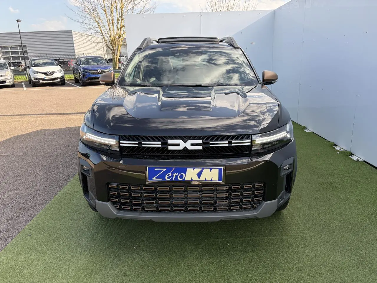 Vue avant du Dacia Bigster noir nacré 2025 avec calandre et détails brun cuivré, toit panoramique ouvrant visible.