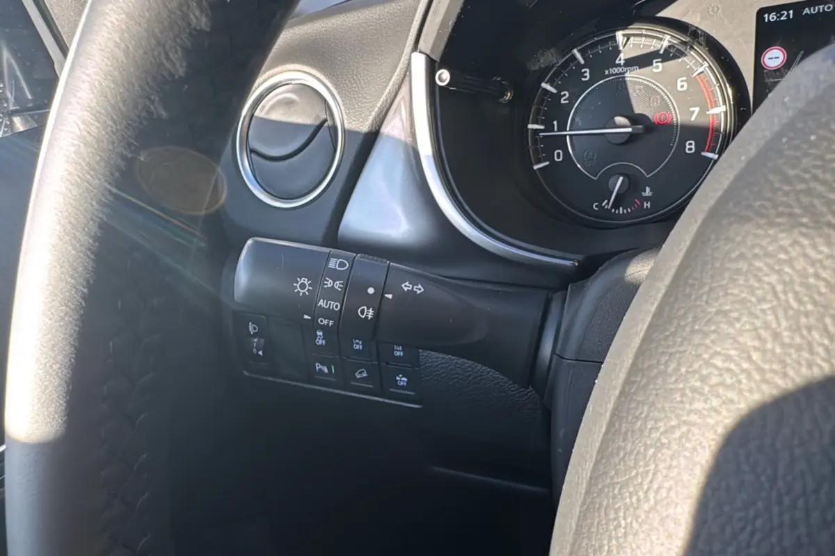 Vue rapprochée du tableau de bord côté gauche du Suzuki Vitara 2025 gris Titan, avec commandes d’éclairage et compte-tours.