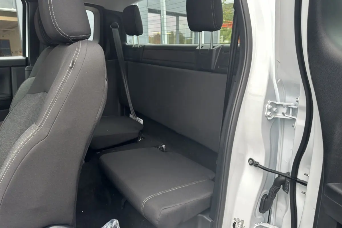 Vue intérieure côté droit du Ford Ranger blanc glacier 2026, sièges arrière rabattus et tissu gris foncé.