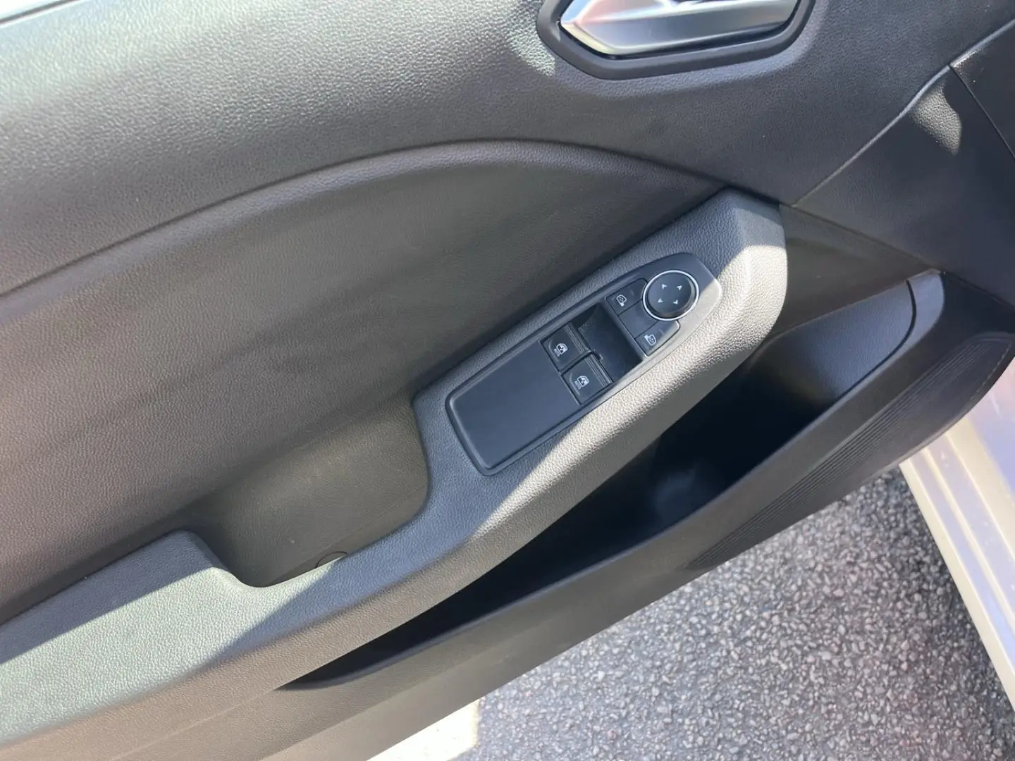 Gros plan sur la porte avant gauche noire de la Renault Clio 1.6 E-Tech 140ch Business, avec commandes électriques.