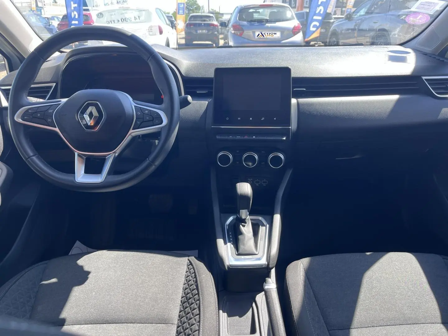 Vue intérieure avant de la Renault Clio 1.6 E-Tech 2021, tableau de bord noir avec écran tactile et volant multifonction.