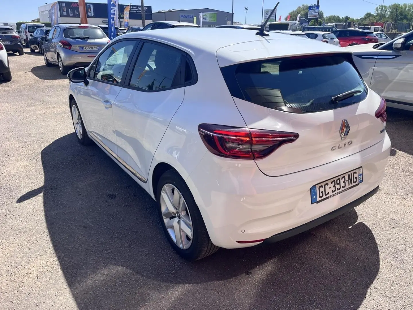 Vue 3/4 arrière droite d'une Renault Clio blanche Quartz de 2021 avec feux arrière LED et jantes alliage.