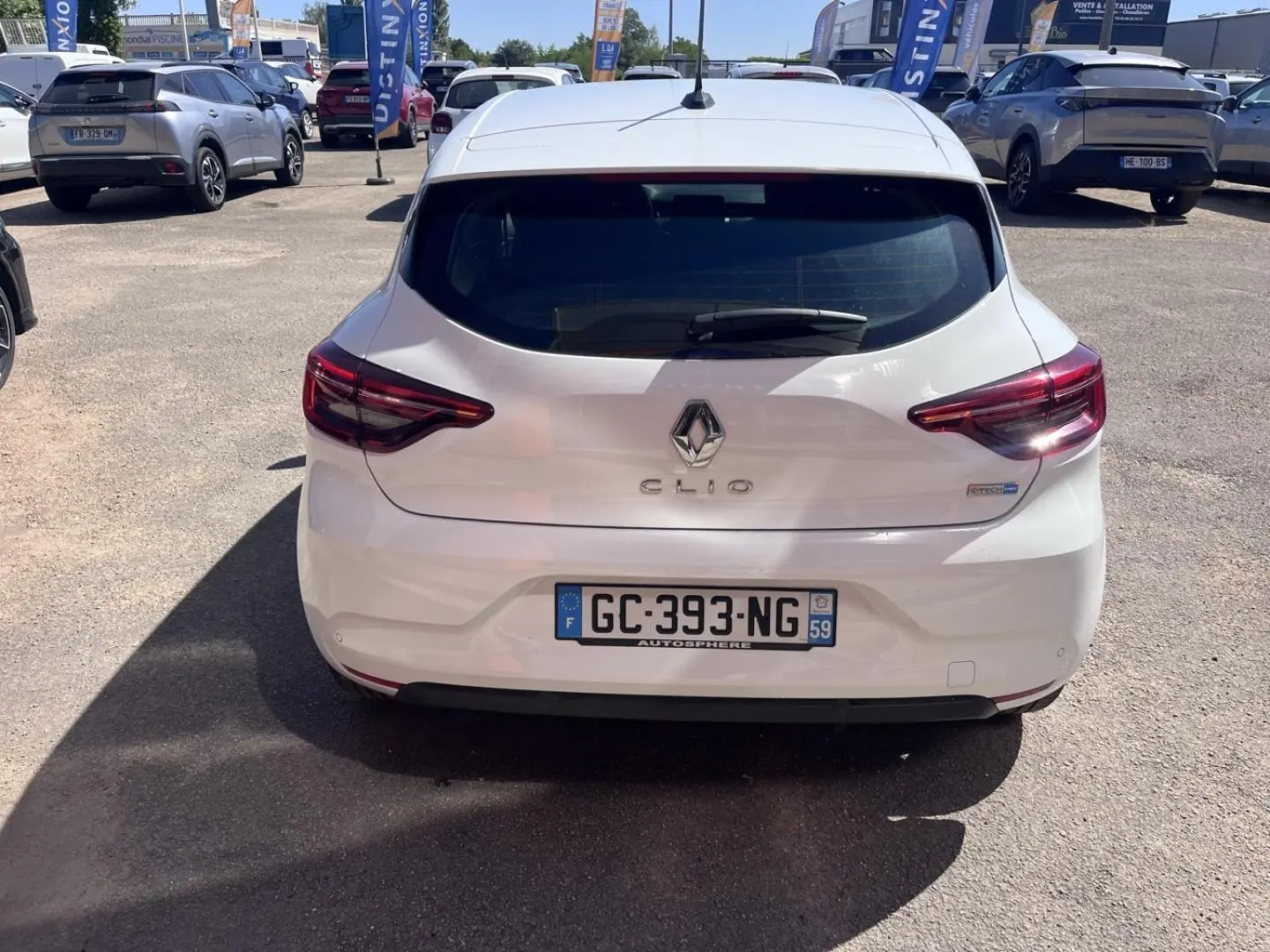 Vue arrière d'une Renault Clio 1.6 E-Tech blanc Quartz, avec feux arrière LED et becquet intégré.