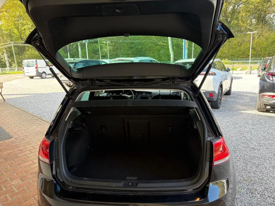 Vue arrière ouverte d'une Volkswagen Golf 7 noire de 2016, mettant en valeur le coffre vide et l'intérieur visible.