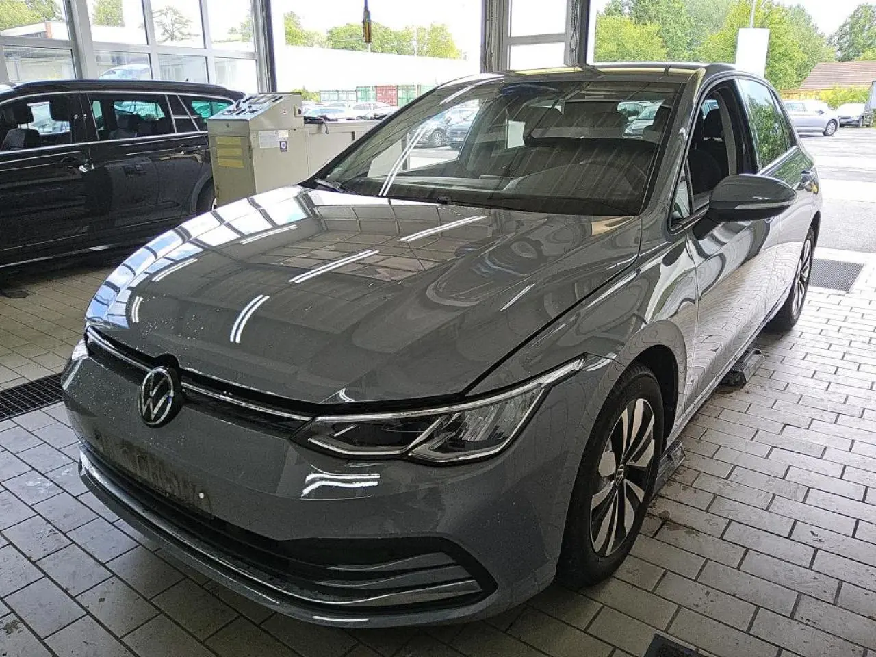 Volkswagen Golf 8 gris lunaire vue 3/4 avant droit, avec phares LED et jantes alliage Norfolk 16 pouces.