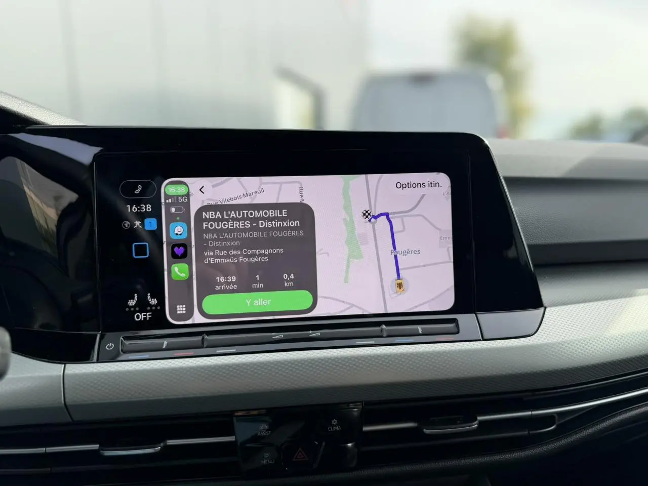 Vue rapprochée de l'écran tactile central de la Volkswagen Golf 8 gris lunaire, affichant la navigation GPS.