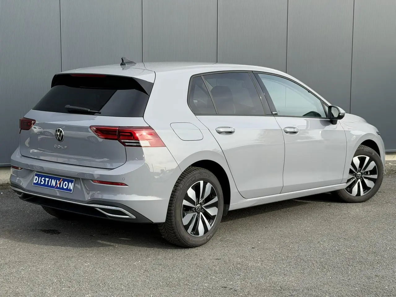 Volkswagen Golf 8 gris lunaire vue 3/4 arrière droit avec feux arrière LED et jantes alliage distinctives.