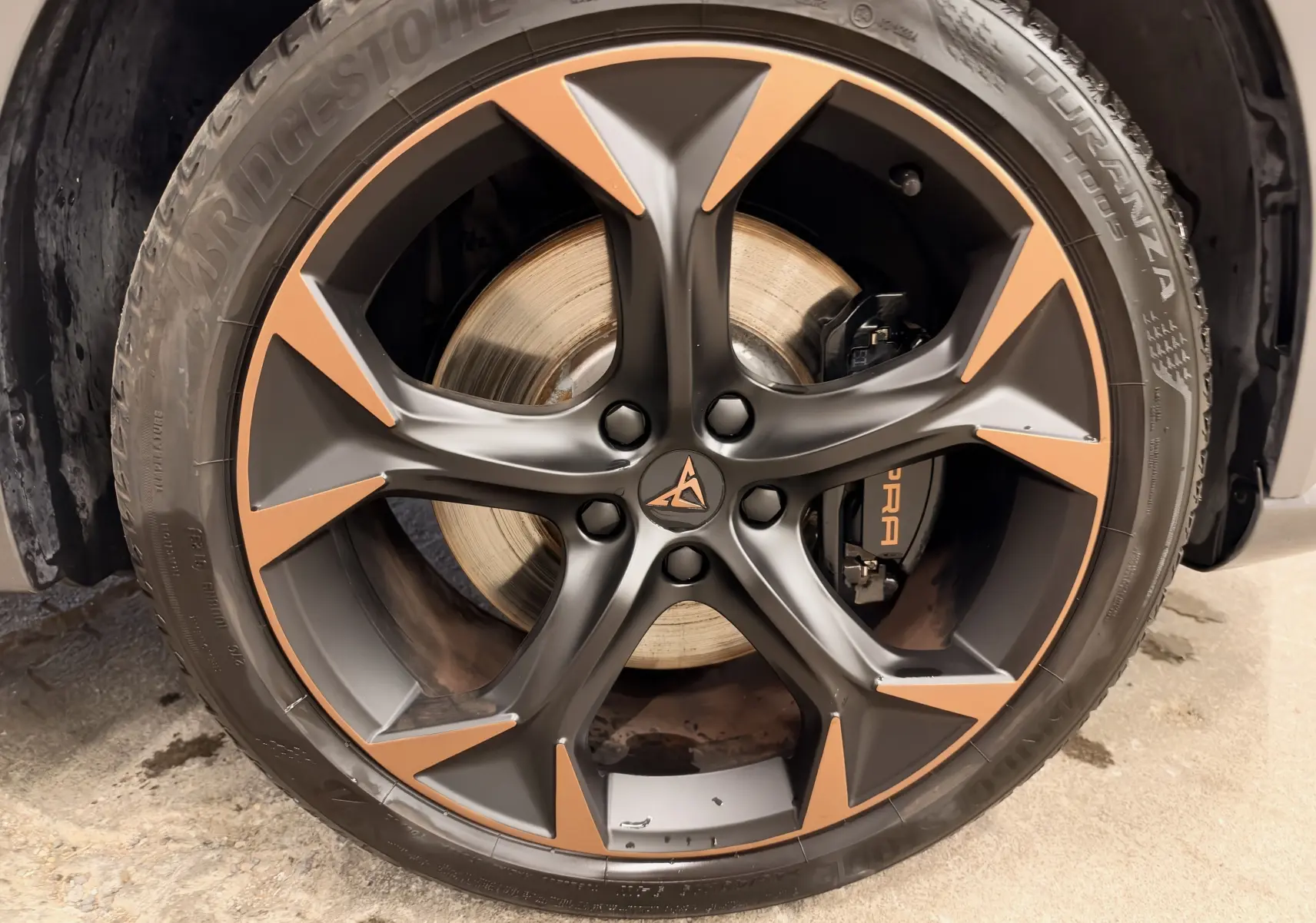 Gros plan sur la jante bicolore noire et cuivre avec logo CUPRA sur roue avant d’un CUPRA Formentor blanc 2024.