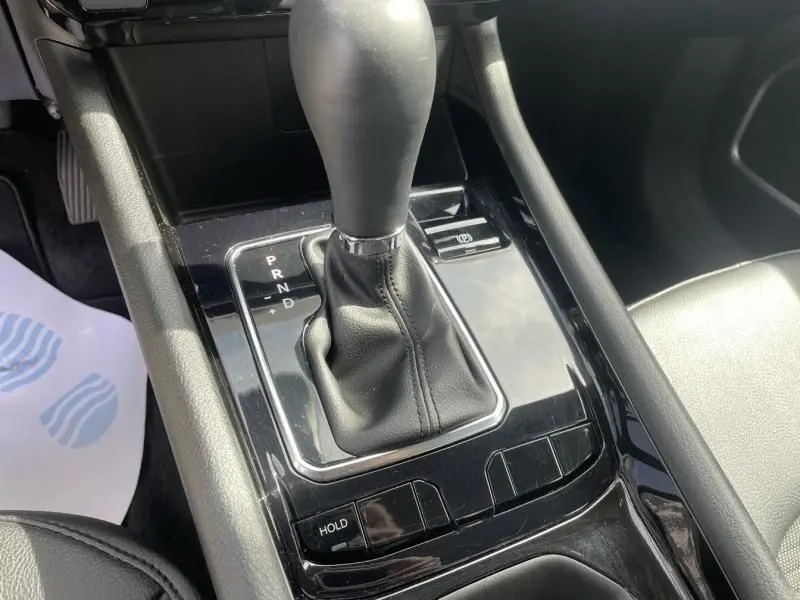 Gros plan sur la console centrale noire du Jeep Compass 2024 blanc, mettant en valeur le levier de vitesse automatique et les commandes adjacentes.