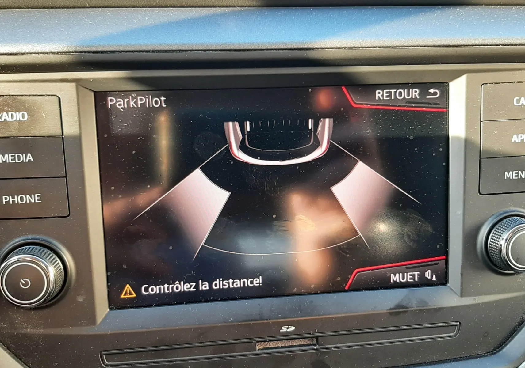 Écran central du tableau de bord d'une SEAT Arona 2019 affichant l'alerte ParkPilot pour le stationnement.