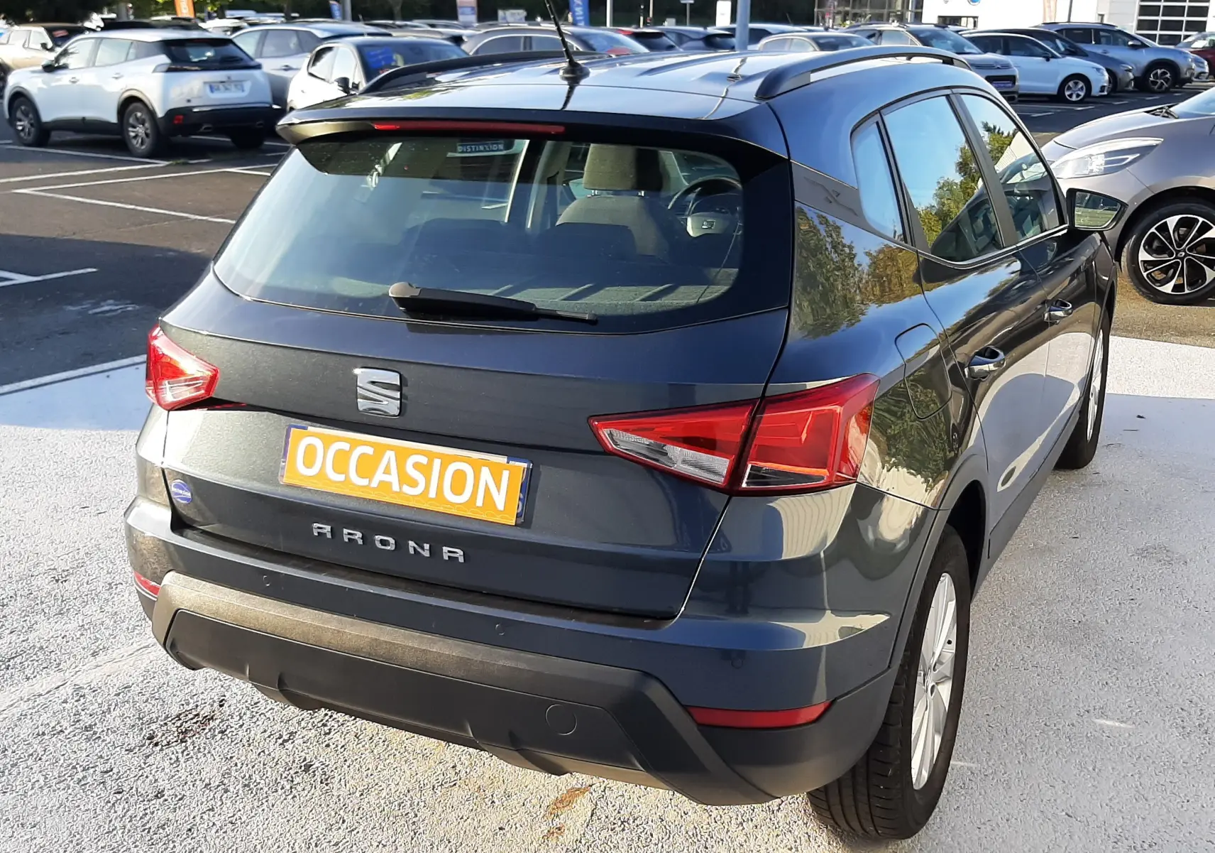 SEAT Arona gris Magnetic avec toit noir, vue 3/4 arrière droit, stationné en extérieur sur parking.