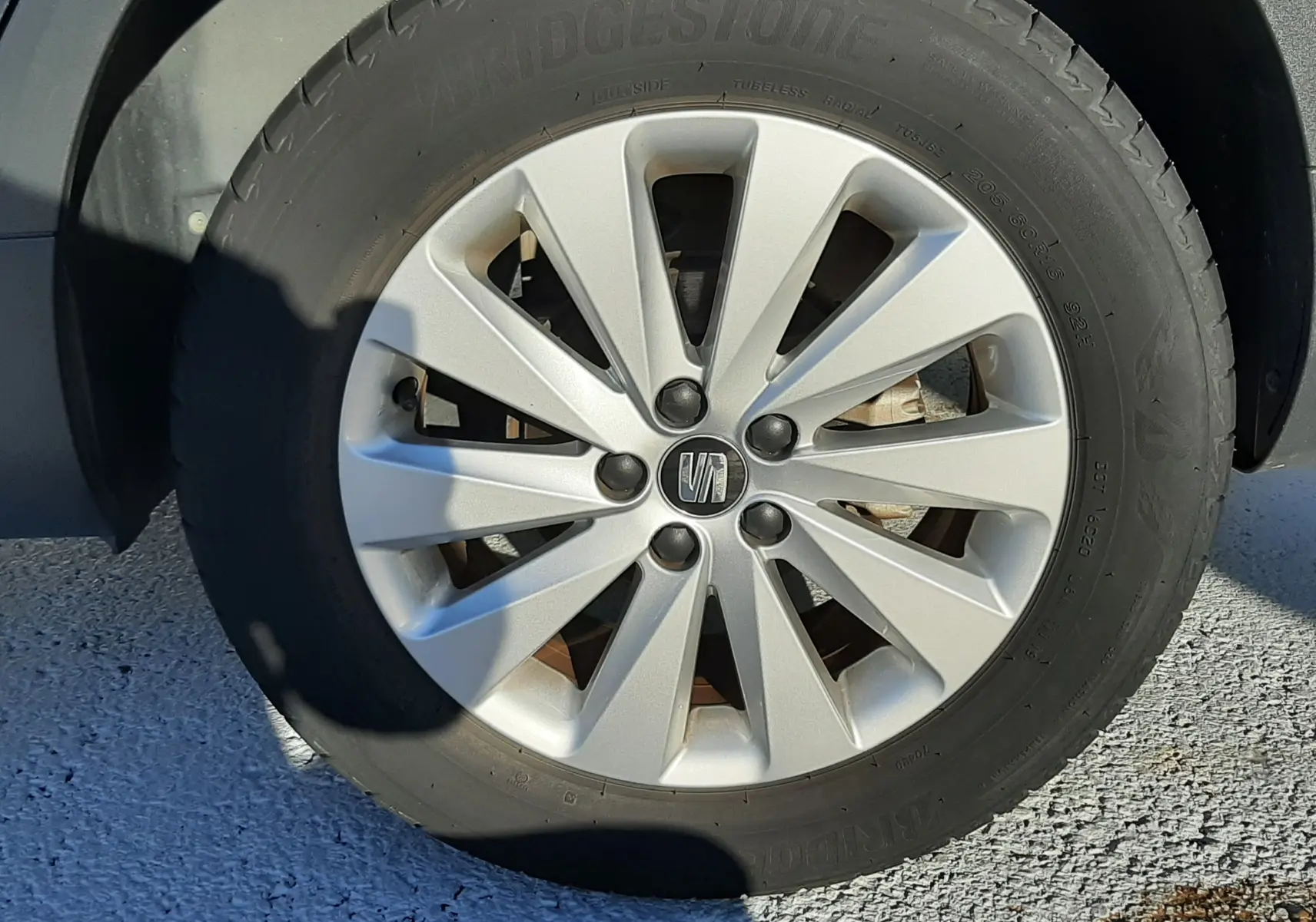 Gros plan sur la jante argentée et le pneu Bridgestone d'une SEAT Arona gris magnetic avec toit noir.