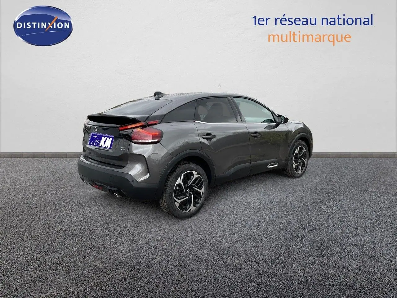 Vue 3/4 arrière droite d'une Citroën C4 2024 gris platinium métal avec jantes bi-ton et feux LED distinctifs.