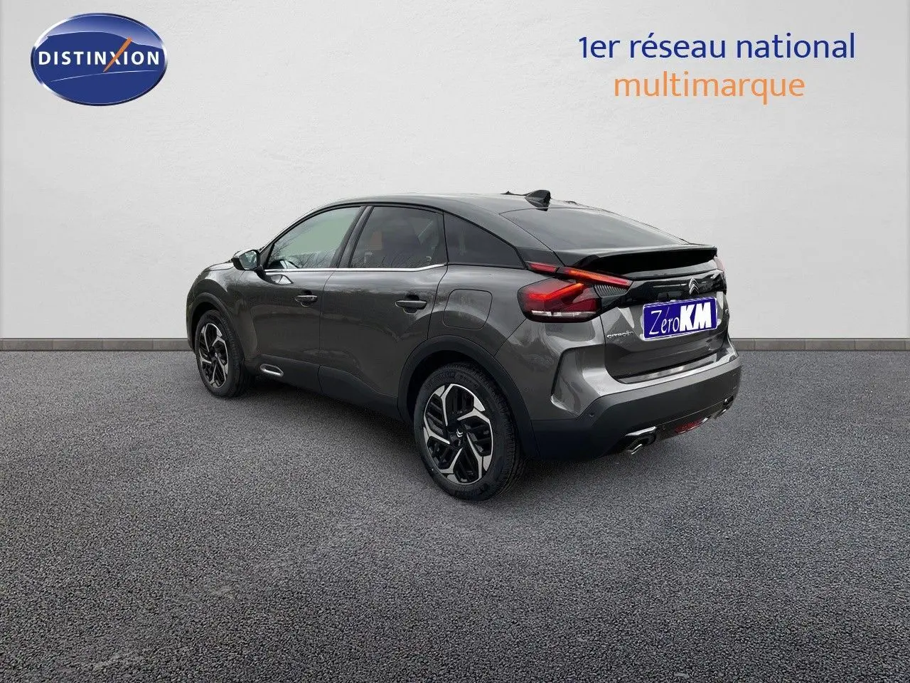 Citroën C4 gris platinium métal vue 3/4 arrière côté gauche avec jantes bi-ton et feux LED distinctifs.