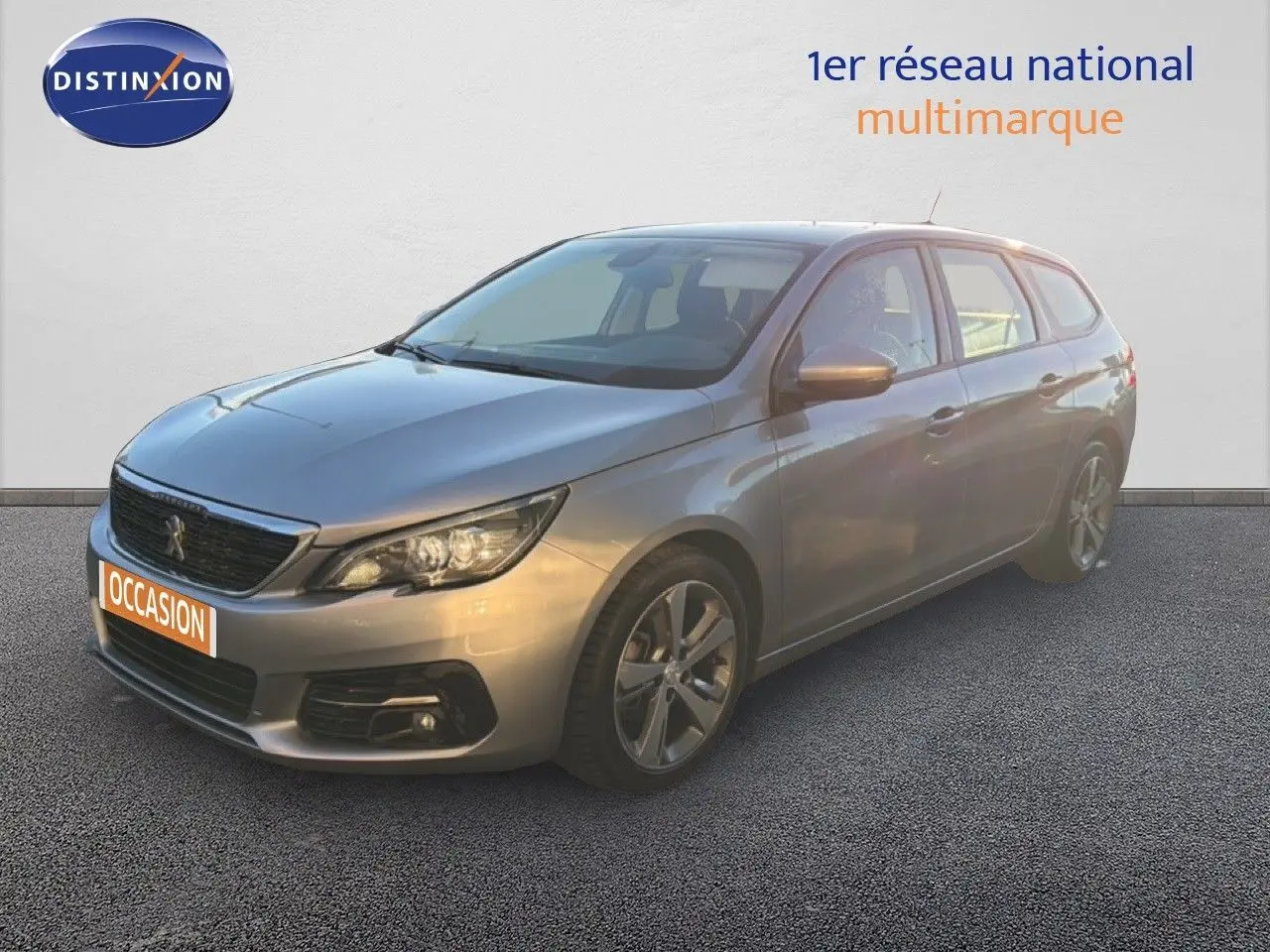 Peugeot 308 SW gris Artense métal vue 3/4 avant droit, avec jantes alliage et calandre noire distinctive.