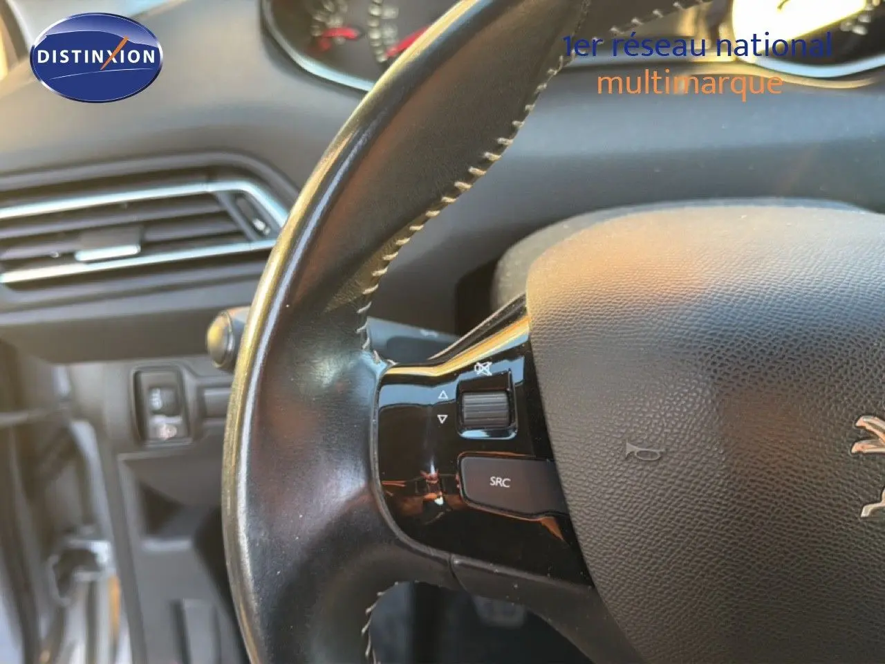 Gros plan sur le volant en cuir noir avec commandes intégrées du Peugeot 308 SW gris Artense Metal de 2019.