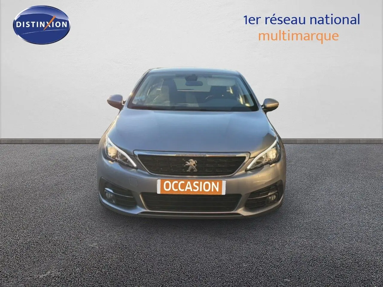 Vue avant d'une Peugeot 308 SW gris Artense métal avec plaque "OCCASION" sur fond neutre.