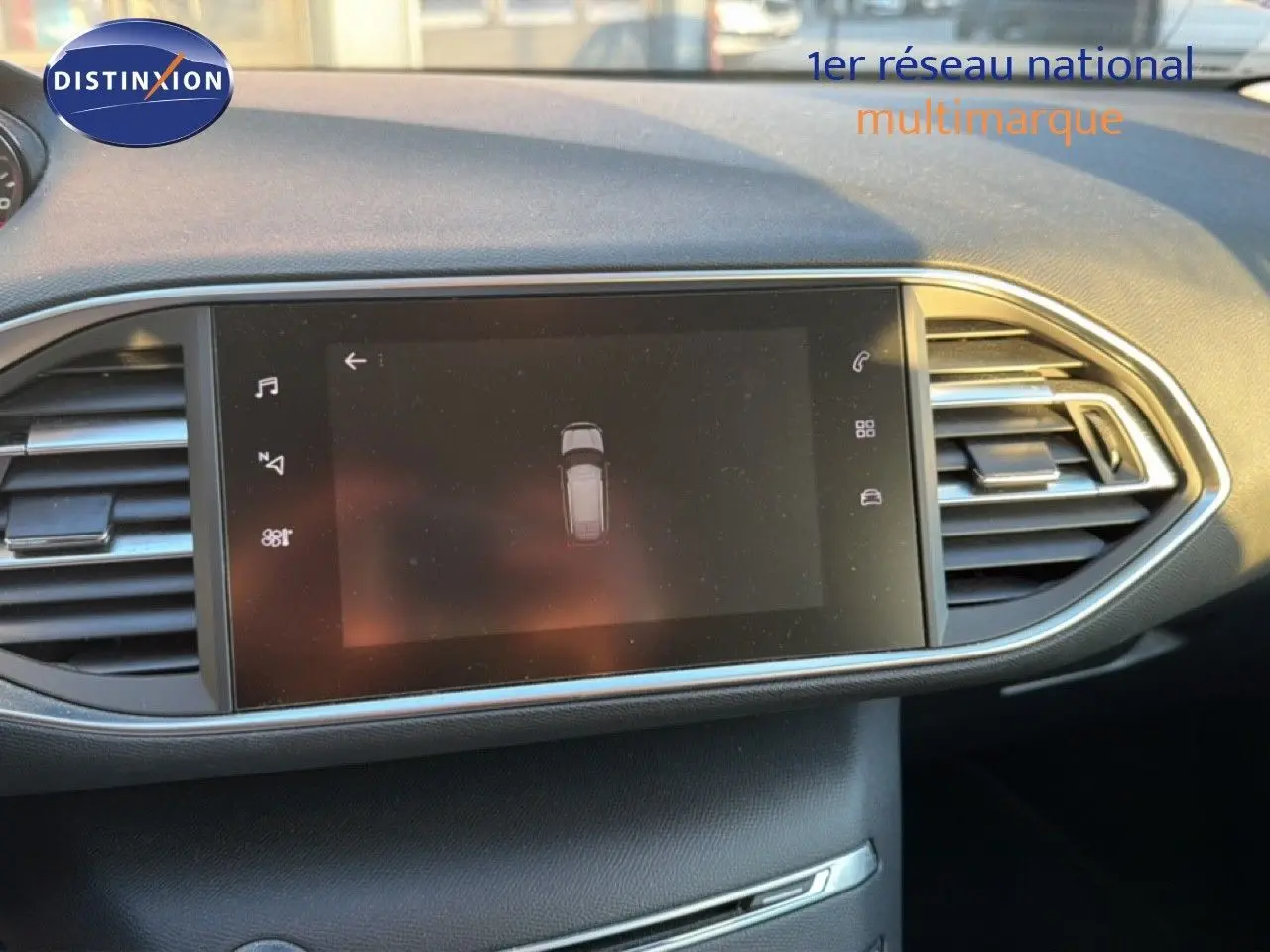 Écran tactile central du tableau de bord du Peugeot 308 SW 2019 avec commandes et aérateurs latéraux visibles.