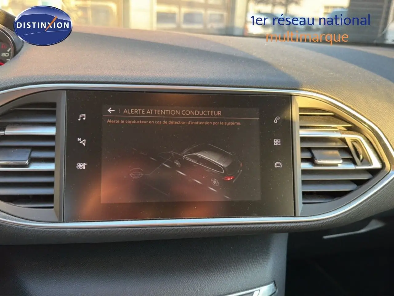 Écran central tactile affichant une alerte de vigilance conducteur dans l'habitacle d'une Peugeot 308 SW gris Artense.