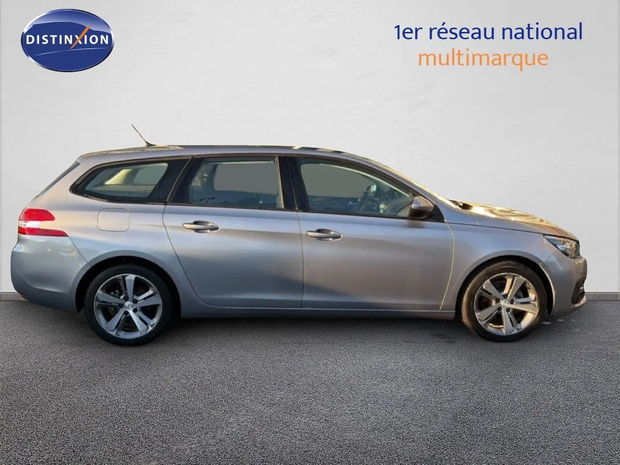 Peugeot 308 SW gris Artense métal vue de profil côté gauche sur fond neutre, jantes alliage visibles.