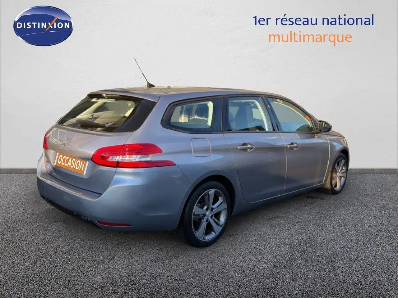 Vue 3/4 arrière droite d'une Peugeot 308 SW gris Artense métallisé avec jantes alliage et feux arrière LED.