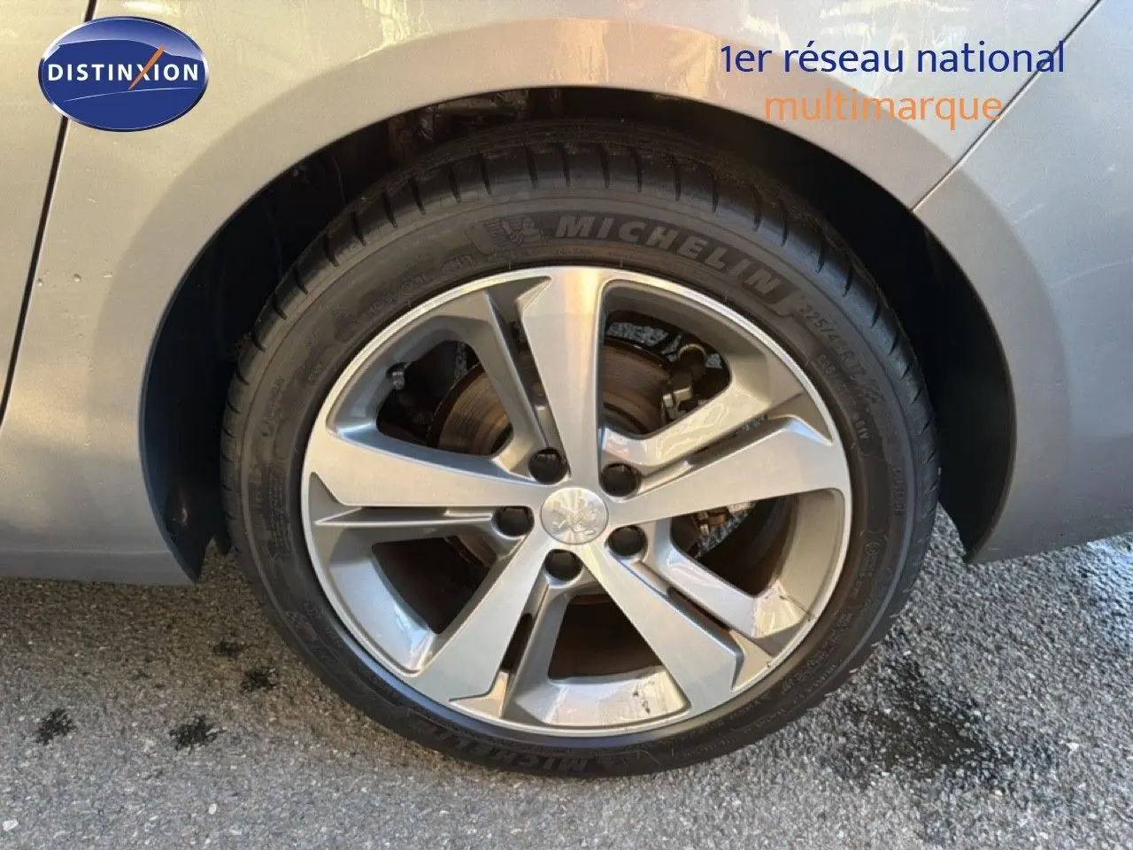 Gros plan sur la roue avant gauche d'une Peugeot 308 SW gris Artense métal avec jante alliage 17 pouces biton.