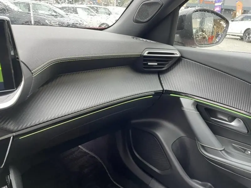 Intérieur du Peugeot 2008 130 GT-LINE 2022 côté passager, avec tableau de bord noir et surpiqûres vertes contrastantes.