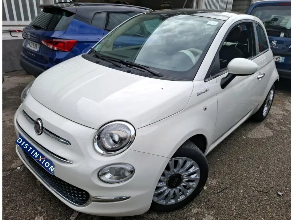 Vue 3/4 avant droite d'une Fiat 500 blanche Bossa Nova avec jantes multibranches et badge Dolcevita sur l'aile.