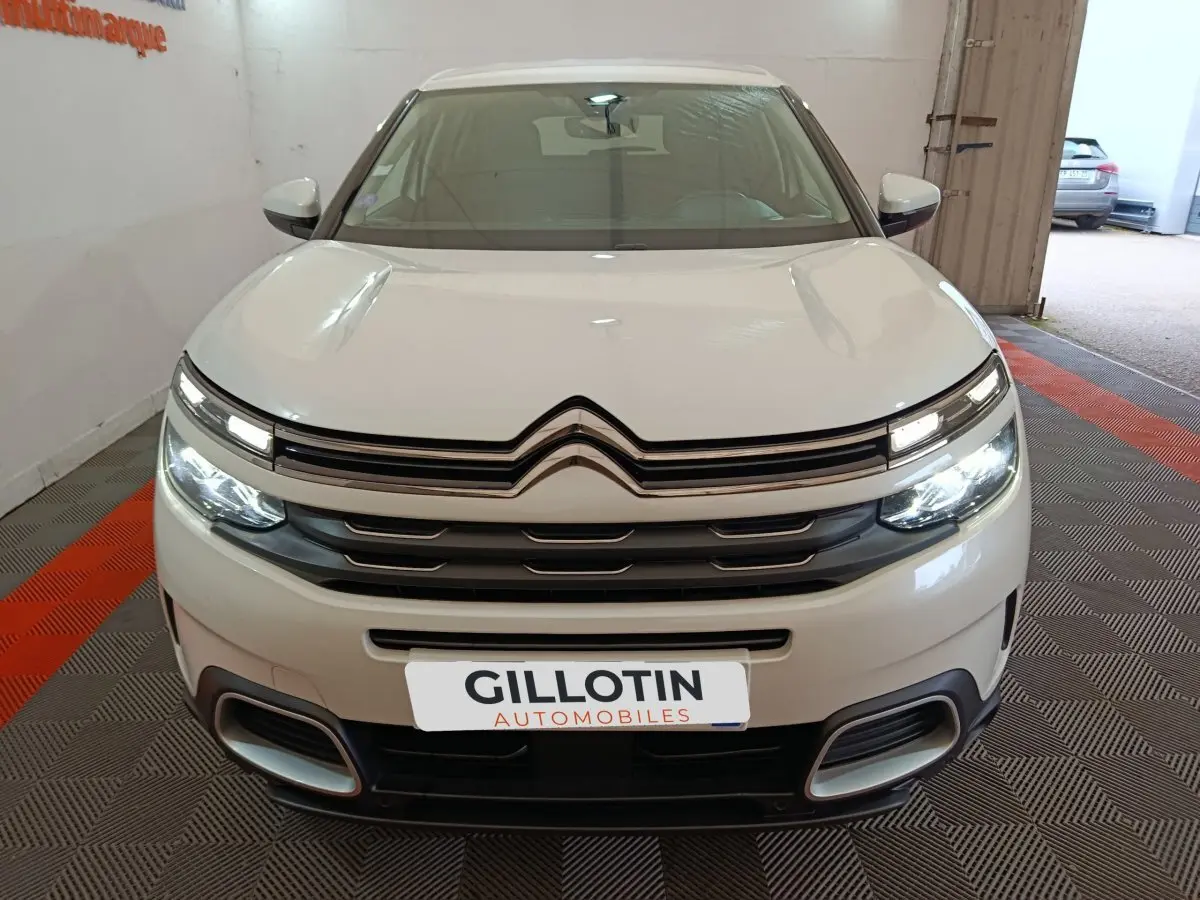 Vue de face du Citroën C5 Aircross blanc avec phares LED allumés et calandre distinctive en double chevron.