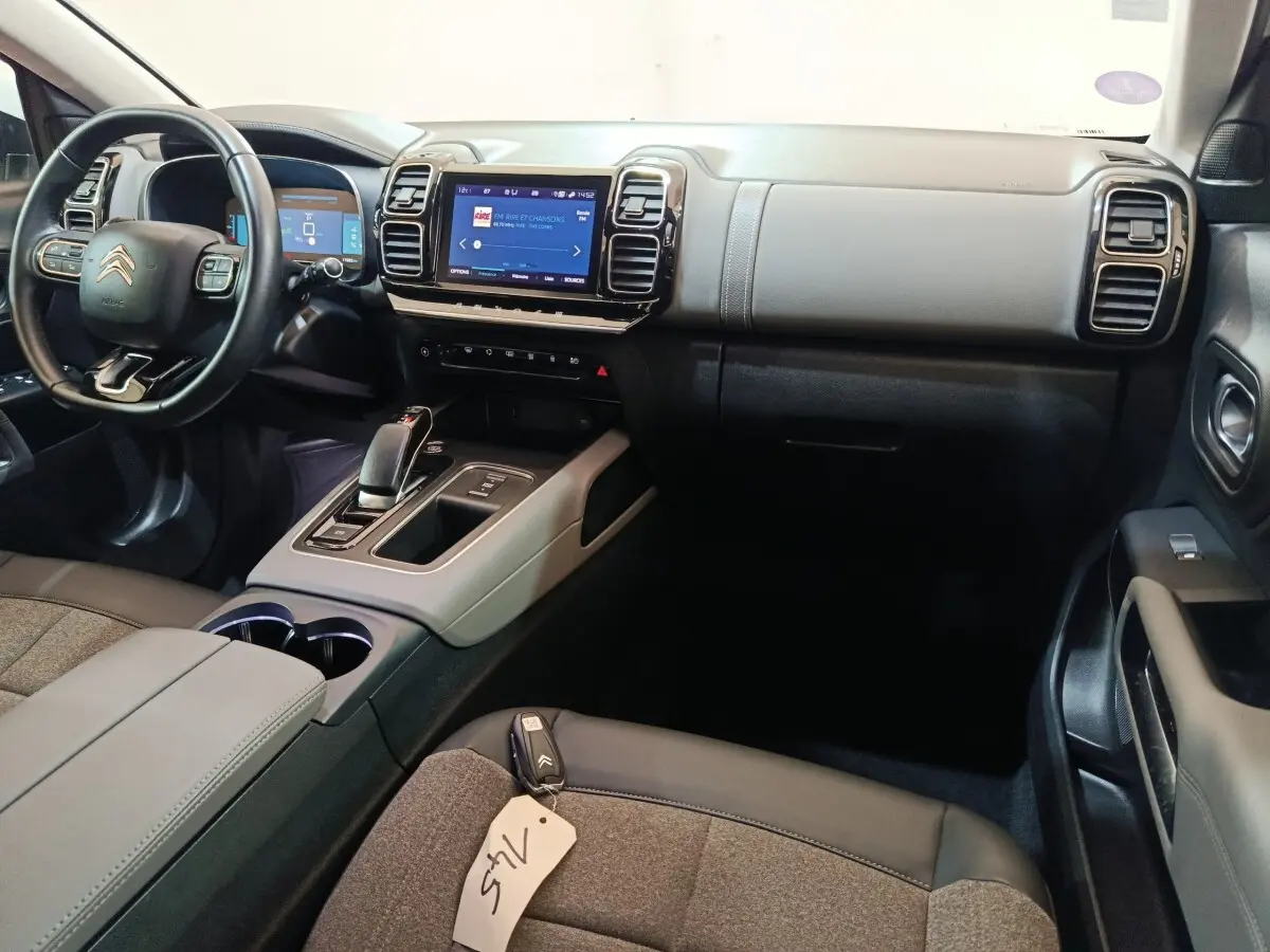 Intérieur avant droit du Citroën C5 Aircross Hybrid blanc 2021, tableau de bord avec écran tactile et volant multifonctions.