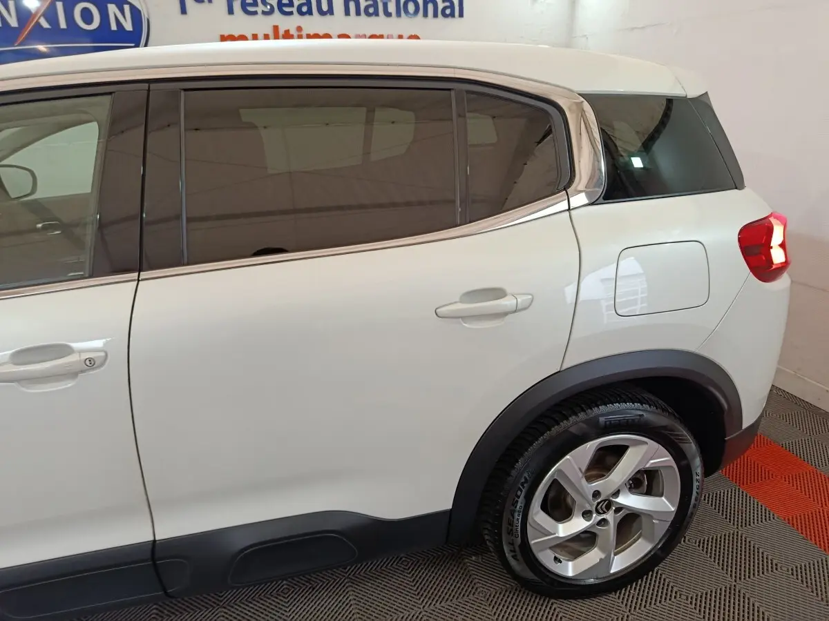 Vue latérale droite du Citroën C5 Aircross blanc hybride, mettant en valeur les vitres teintées et la jante alliage arrière.