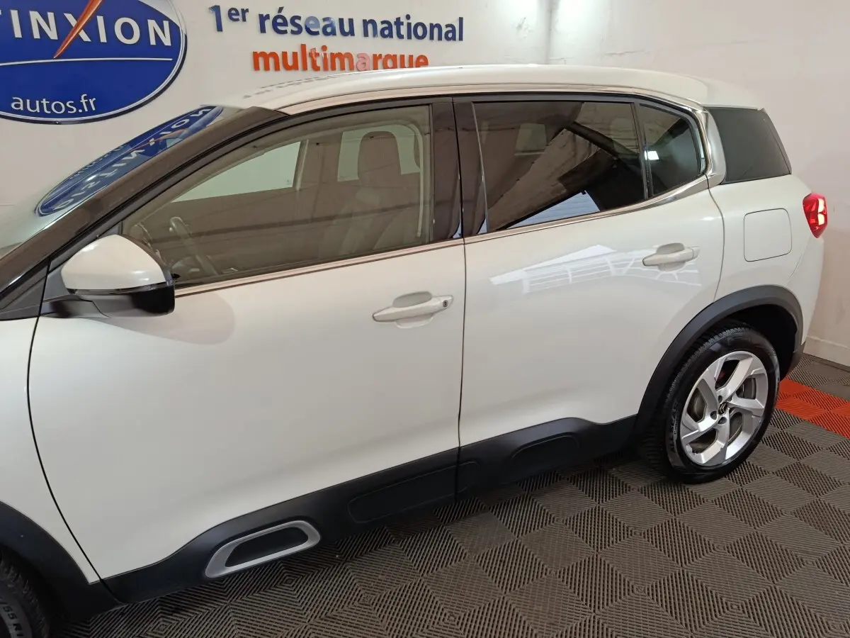 Vue latérale droite d'un Citroën C5 Aircross Hybrid blanc avec jantes alliage et protections noires basses.