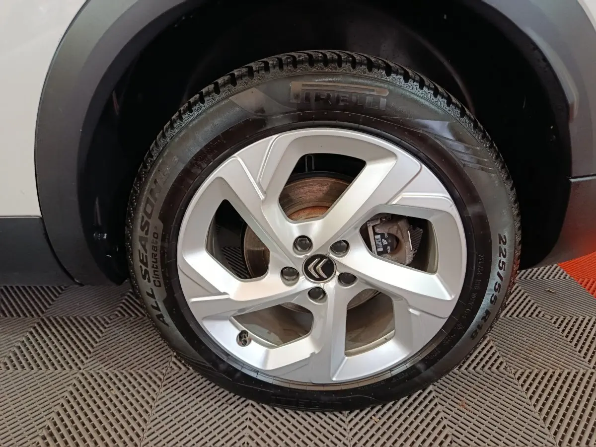 Gros plan sur la roue avant droite blanche d’un Citroën C5 Aircross Hybrid avec jante alliage et pneu Pirelli.