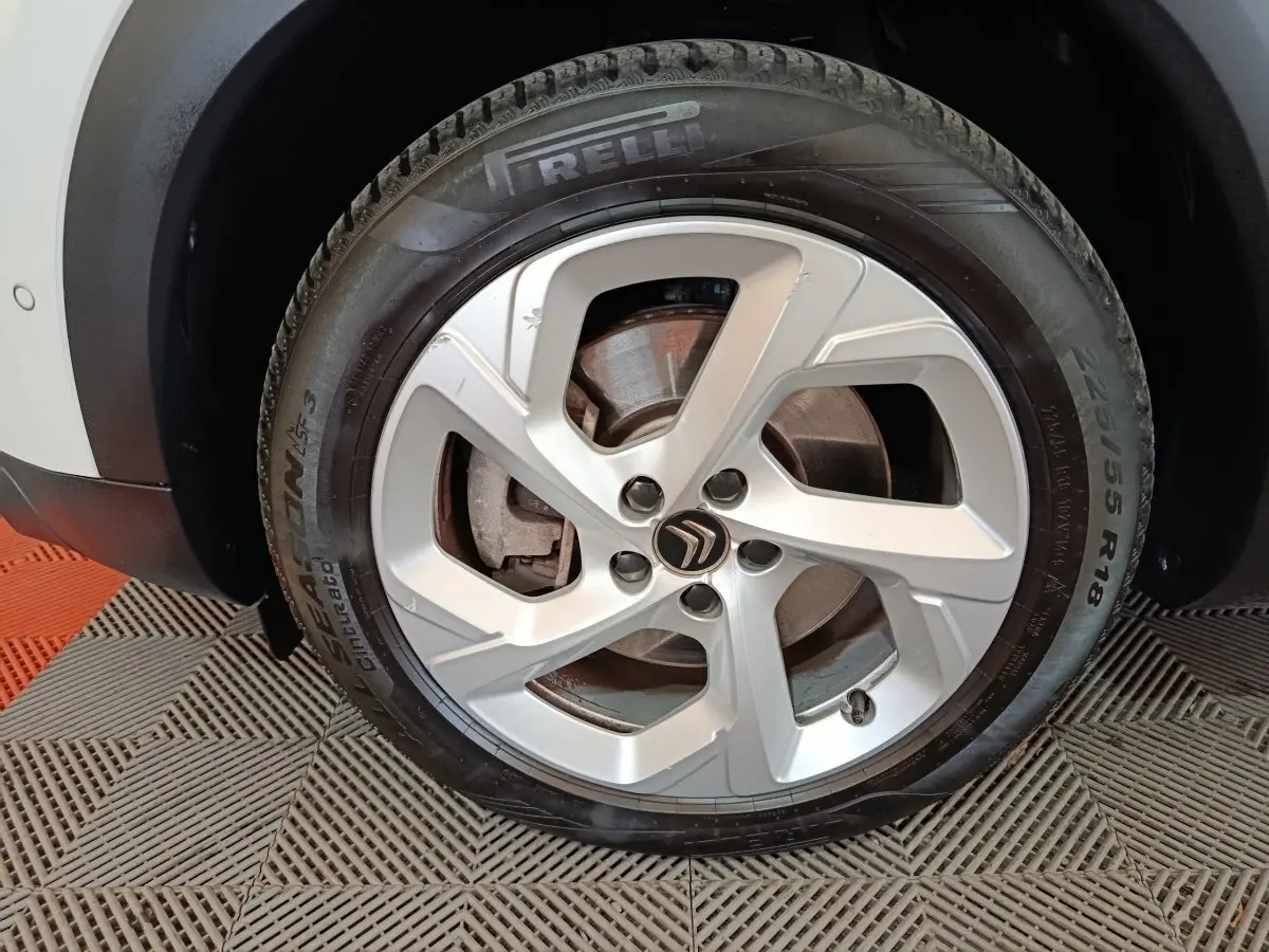 Gros plan sur la roue avant gauche du Citroën C5 Aircross blanc, avec jante alliage et pneu Pirelli visible.