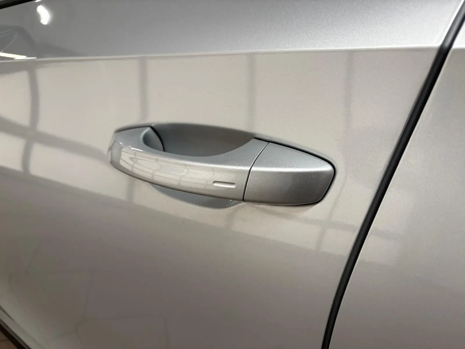 Poignée de porte côté gauche gris argent d'une Skoda Fabia 2025 avec peinture métallisée brillante.