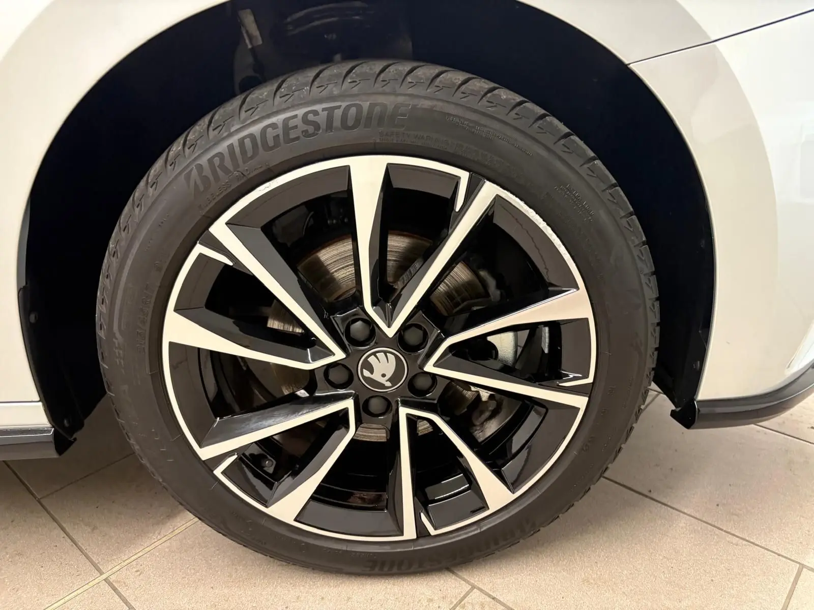 Gros plan sur la roue avant droite d'une Skoda Fabia gris argent avec jante alliage noire et argentée.
