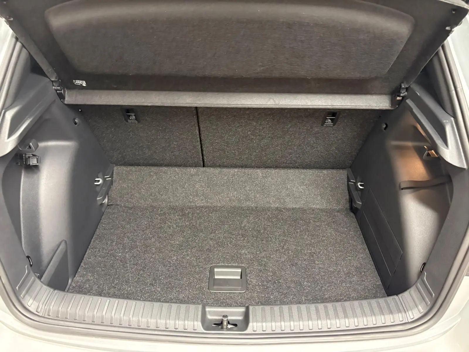 Vue intérieure du coffre ouvert de la Skoda Fabia 2025, montrant le double plancher variable et la finition en tissu gris.