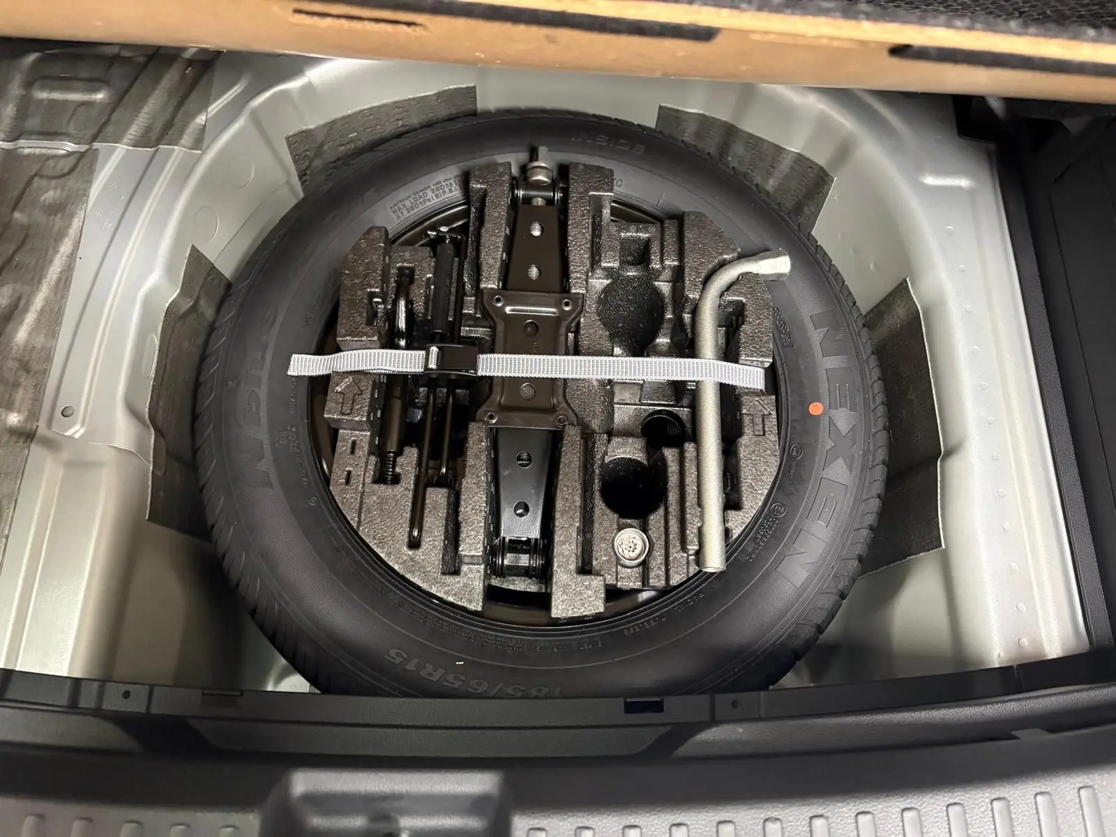 Gros plan sur la roue de secours et les outils de bord dans le coffre d'une Skoda Fabia 1.0 TSI 116 DSG7 Monte Carlo 2025.