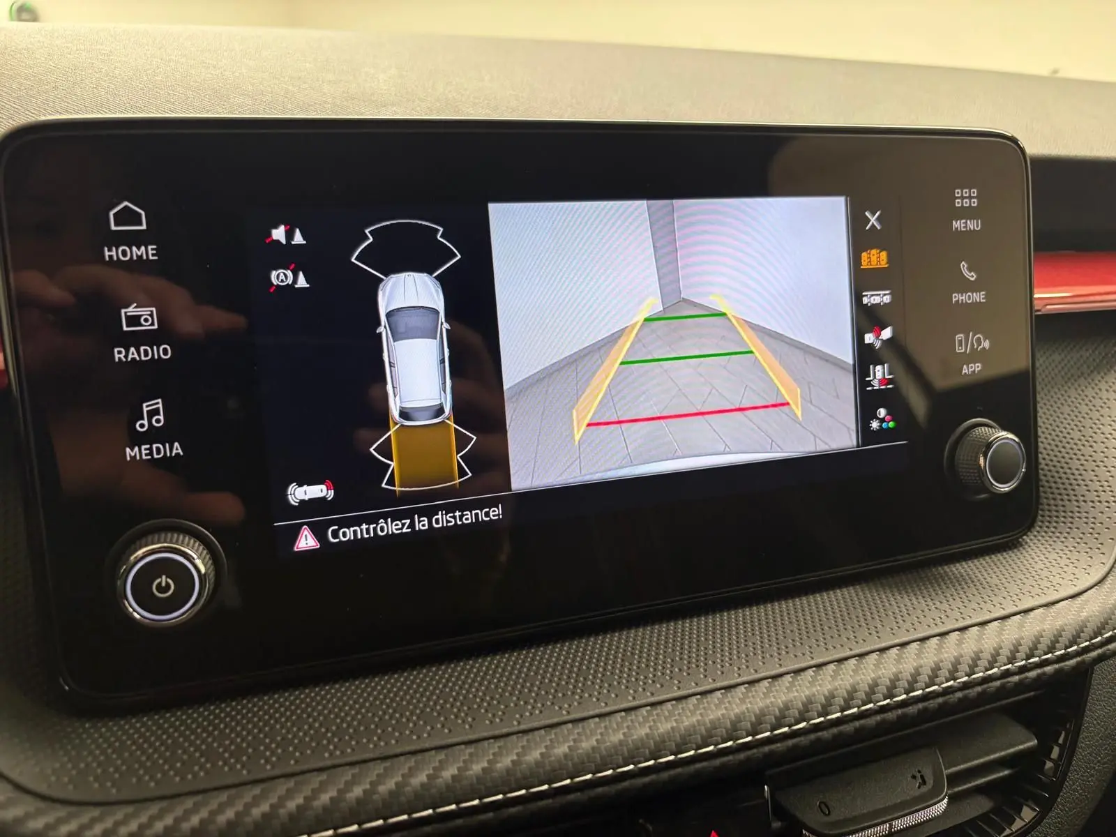Écran central de la Skoda Fabia 2025 montrant la caméra de recul avec guidage dynamique et alertes de distance.