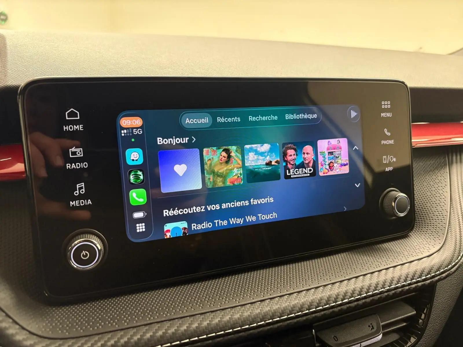 Écran tactile central du tableau de bord de la Skoda Fabia 2025 avec interface multimédia et commandes autour.