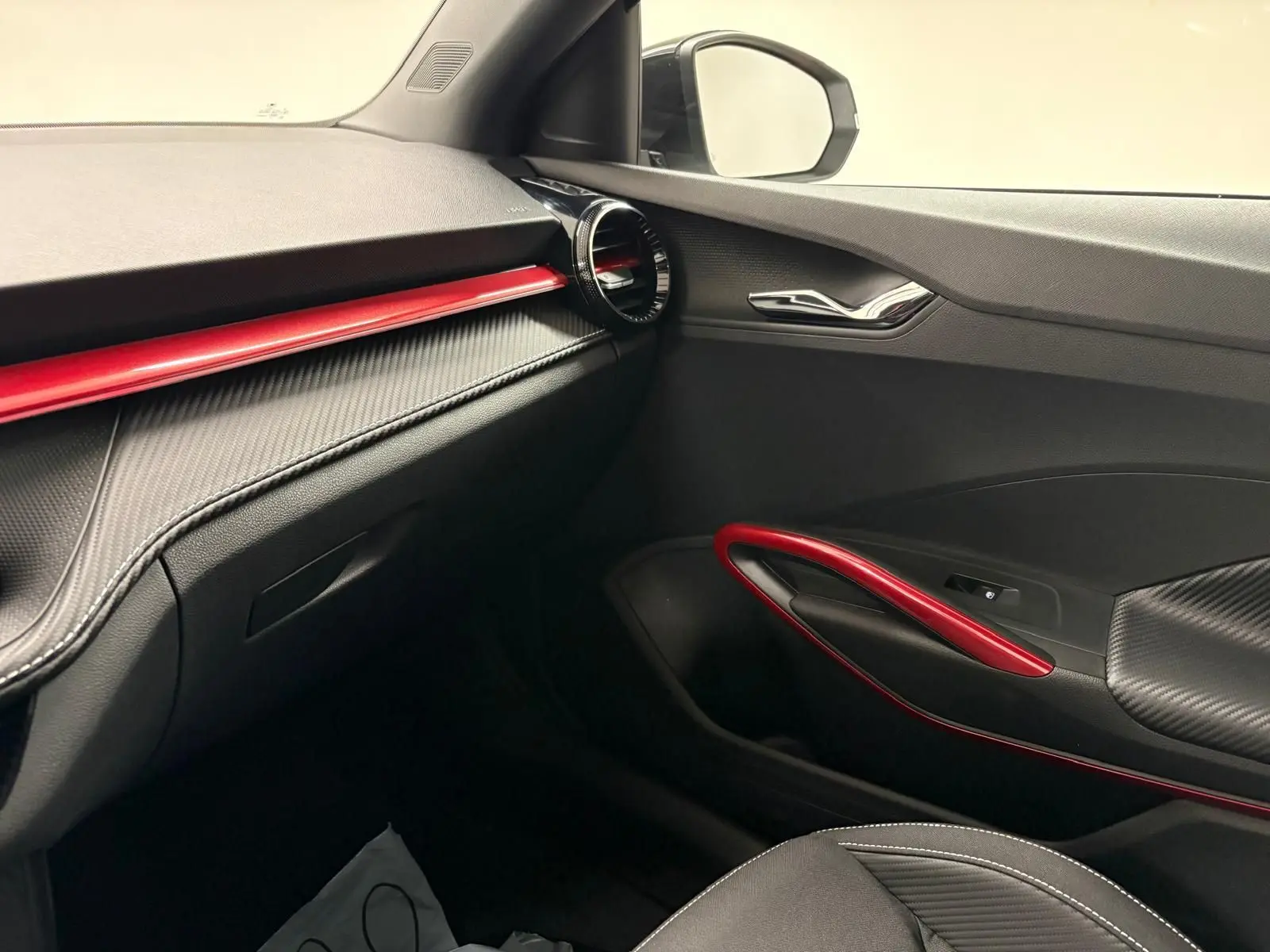 Intérieur côté passager de la Skoda Fabia Monte Carlo 2025 avec garnitures noires et inserts rouges contrastants.
