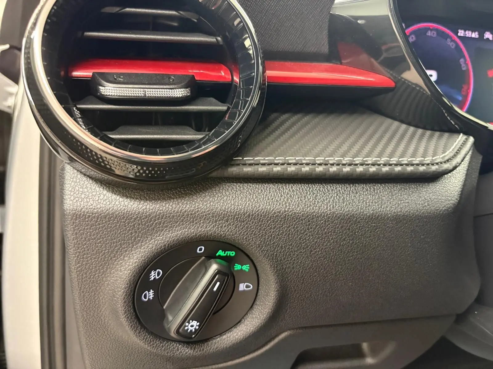 Gros plan sur la commande des phares et la sortie d’air avec insert rouge du tableau de bord de la Skoda Fabia Monte Carlo 2025.