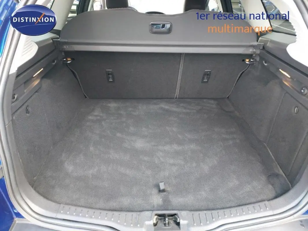 Coffre ouvert d’une Ford Focus SW bleu foncé 2018, montrant un espace de chargement propre et spacieux.